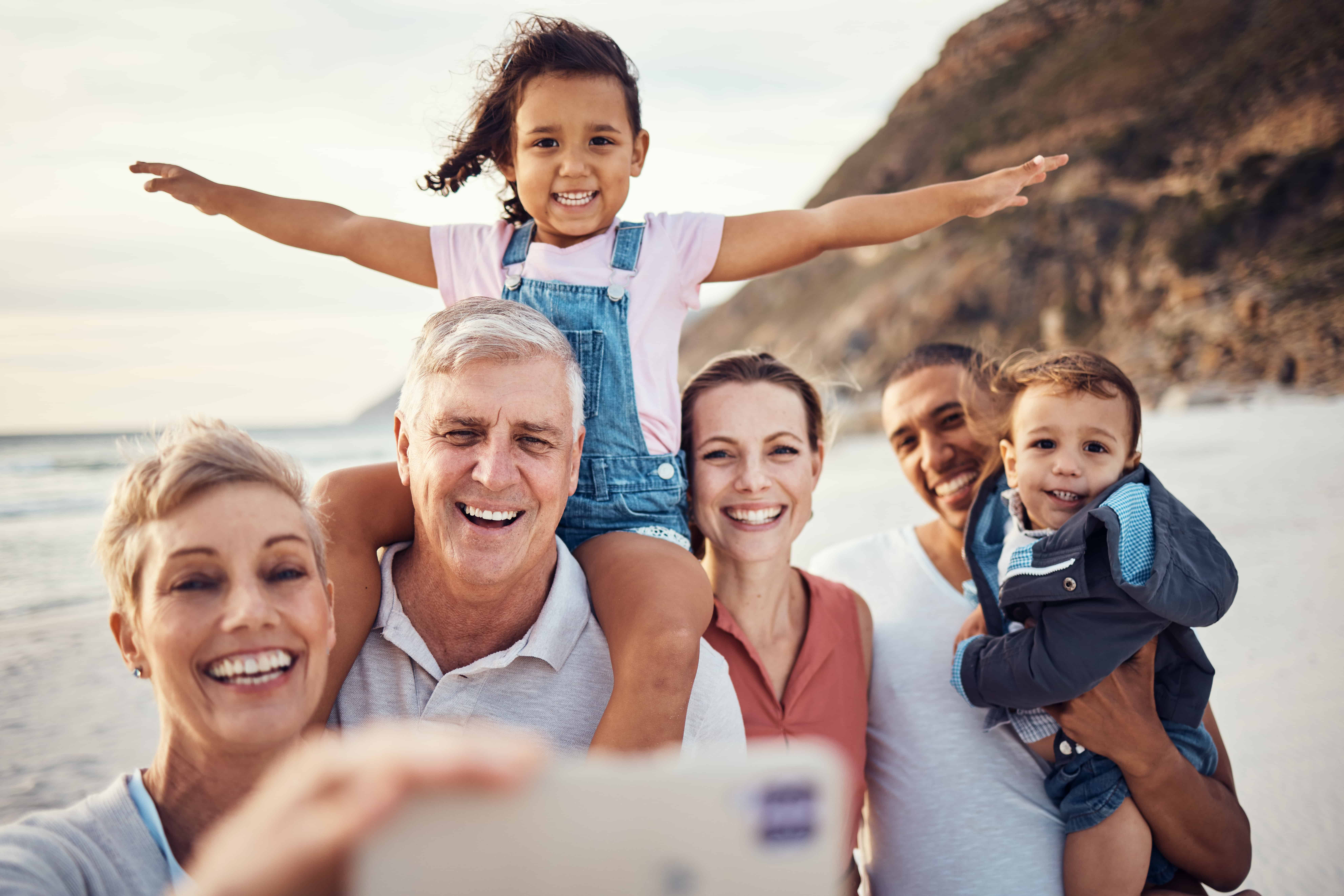 Happiness, grandparents and parents with children taking picture with smile on phone while on travel holiday